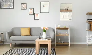 Wandkalender, Design Monatskalender, Motiv Familie mit zwei Kindern spaziert am Strand, hängt im Wohnzimmer