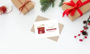 Festliche Weihnachtskarte in weiß, Design rotes Geschenk, Grüße in geschwungener Schrift
