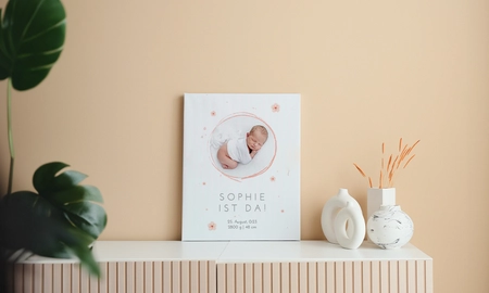 Fotoleinwand, weiß, Motiv Baby umrahmt mit einem Kreis und Blumen in rosa