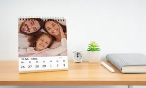 Tischkalender Fotokalender mit kleiner glücklichen Familie, Kalender steht auf Regal mit Wecker und Pflanze