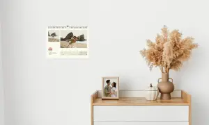 Ein Wandkalender hängt neben einem Schreibtisch, auf dem Fotos stehen