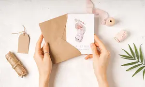 Geburtskarte mit kleinem Fußabdruck schaut aus einem Umschlag